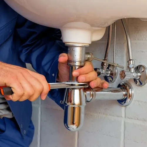 Plumber tightening sink drain pipe